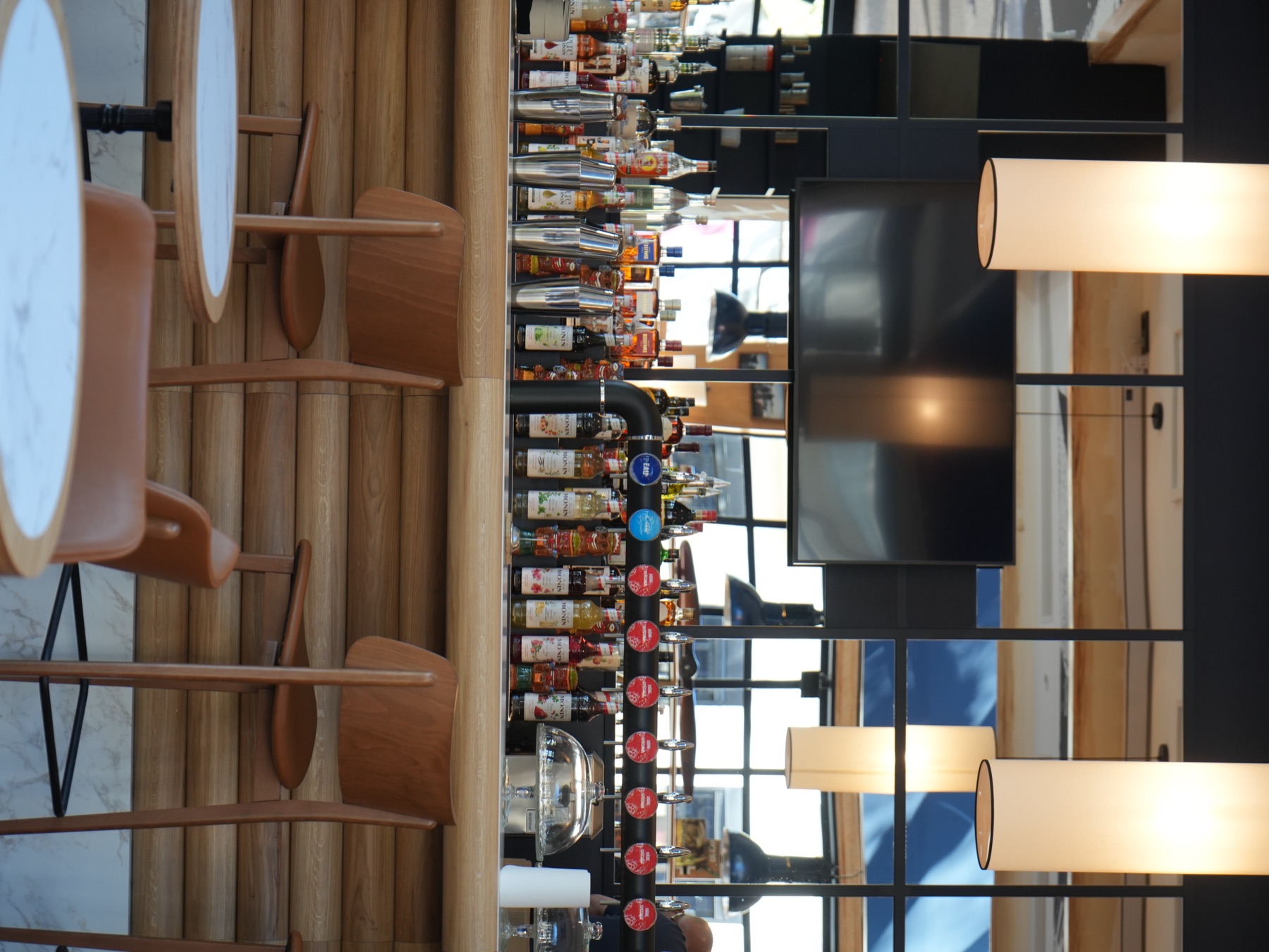 Bar & Bistrot — bar central avec spiritueux, bières pression et tables marbrées à la Brasserie Les Officiers