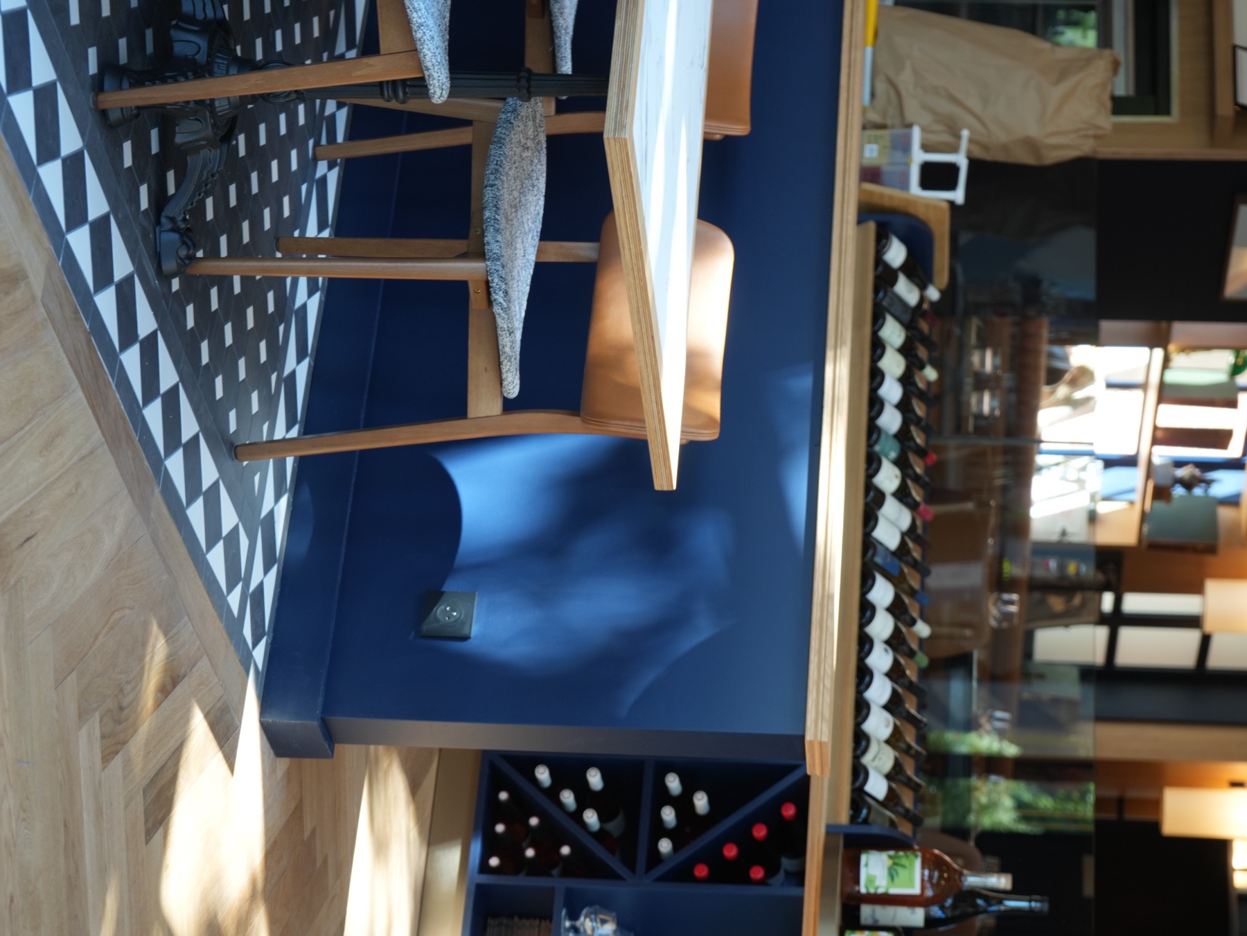 Chaises hautes et tabourets bois devant le comptoir bleu de la Brasserie Les Officiers