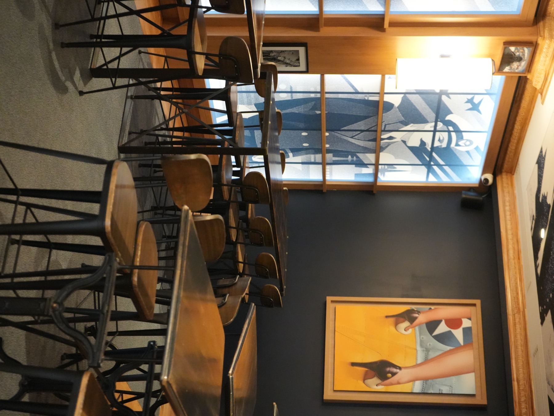Vue d'ensemble de la salle · grandes vitrées, verrière, tables bistrot et fresque bleue signature de la Brasserie Les Officiers