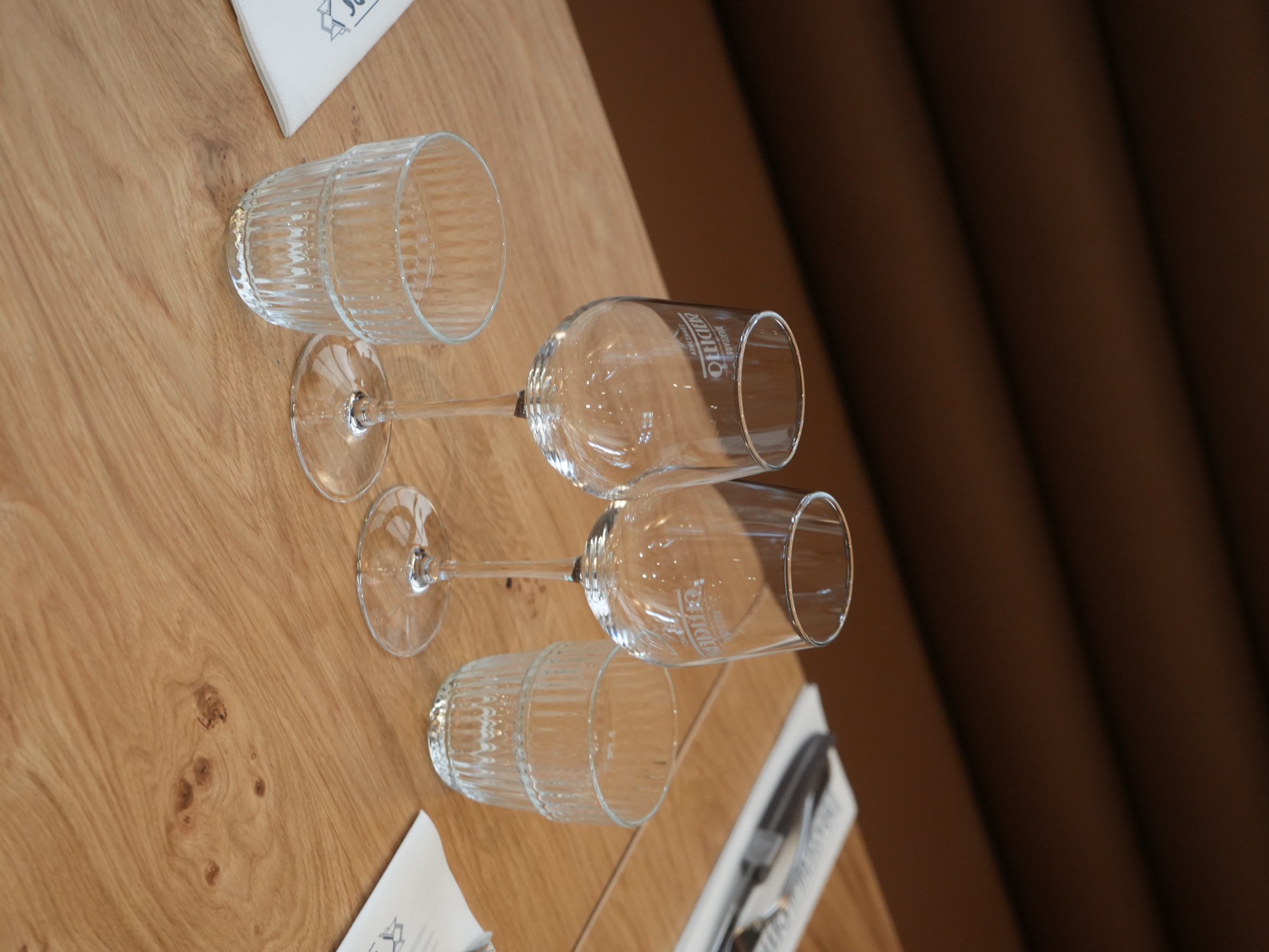 Verres fins dressés sur table en bois · art de la table à la Brasserie Les Officiers