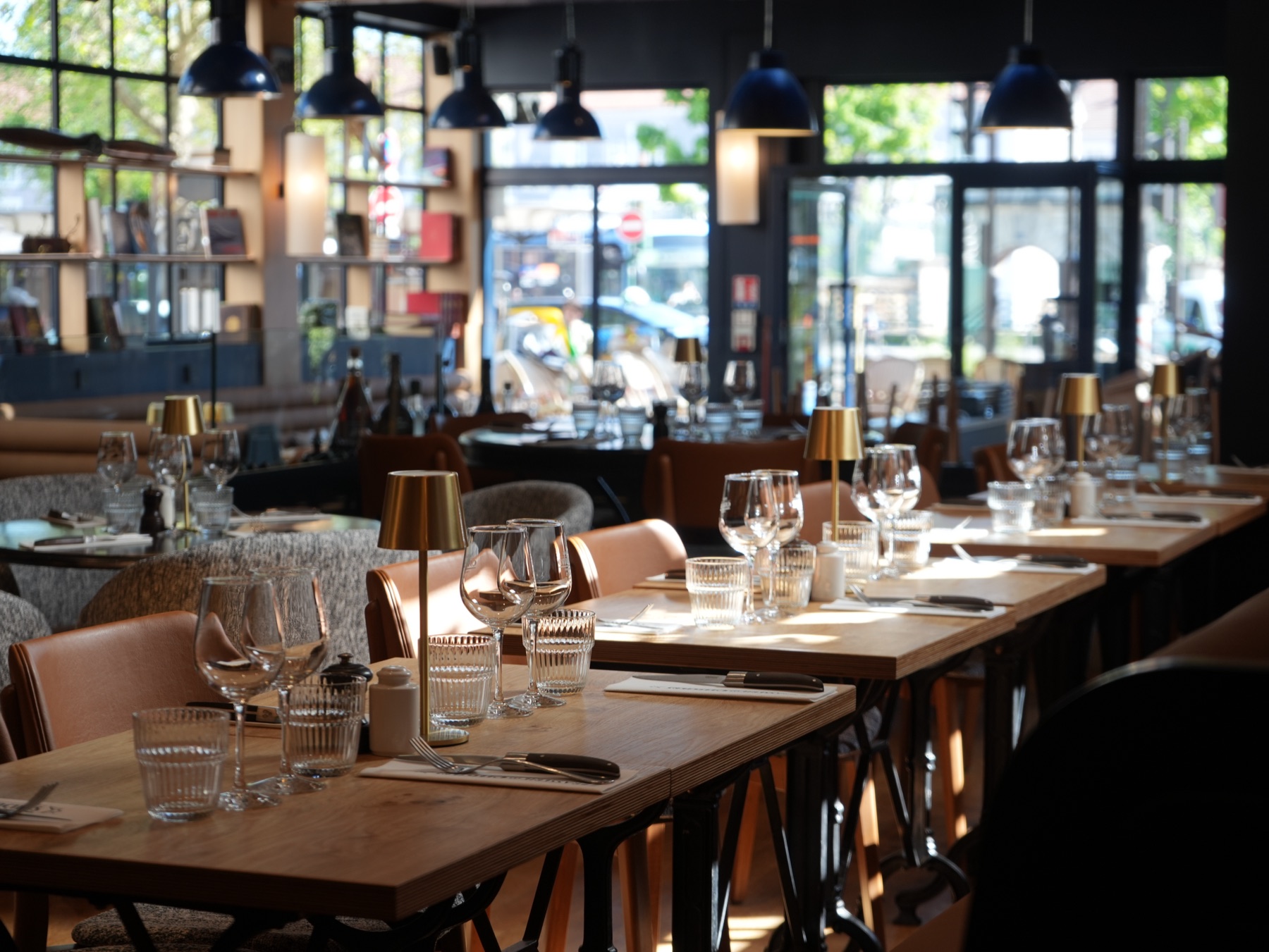 Espace Privatisable — salle dédiée avec grandes vitrées, suspensions bleues et fresque signature à la Brasserie Les Officiers